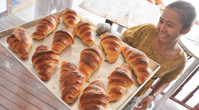 Miss Fon getting the croissants out of the oven. These are crunchy, you can have them soft and golden.